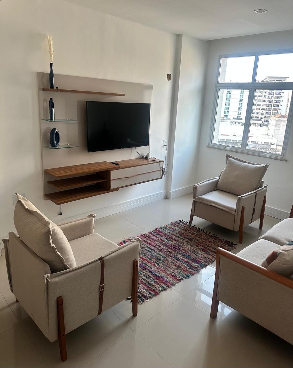 Sala de estar com painel de televisão e luz natural